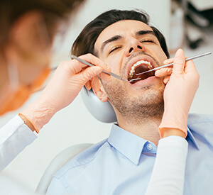 Man receiving dental examination from dentist