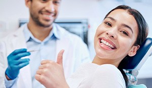 Smiling woman giving thumbs up in treatment chair