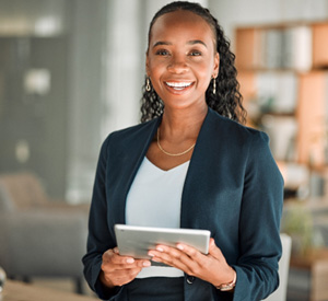 Woman smiling while holding tablet in office