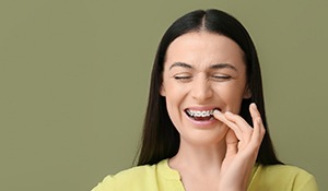 A beautiful woman with braces experiencing oral pain