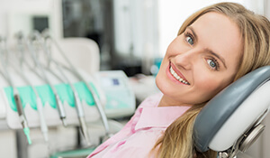 Lady resting on dental chair smiling