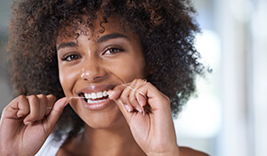 Young lady flossing teeth