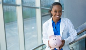 Richardson implant dentist smiling and holding a piggy bank 