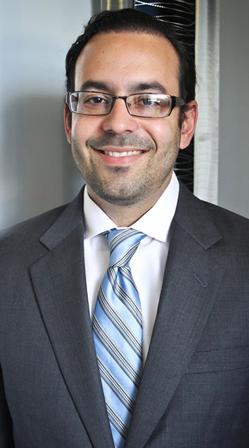 Dr. Jan Ortiz wearing suit smiling