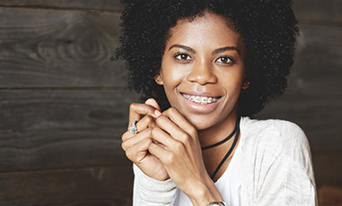 Young lady holding hands together smiling