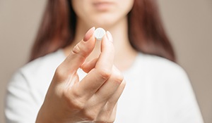 woman holding a pill
