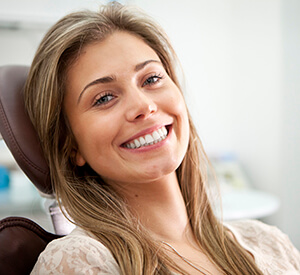 Blonde woman relaxing on dental chair smiling