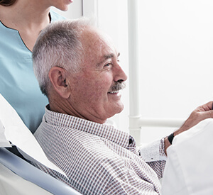 Elderly man in button up smiling