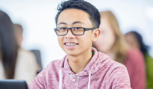 Young boy with glasses and jacket smiling