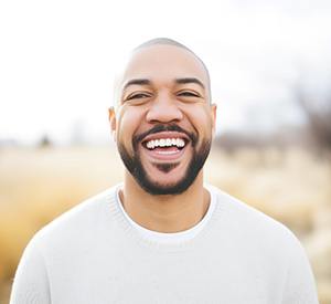 Man in white shirt smiling outside