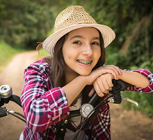girl wearing sun hat riding bike