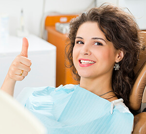 Young Lady giving thumbs up in dental chair
