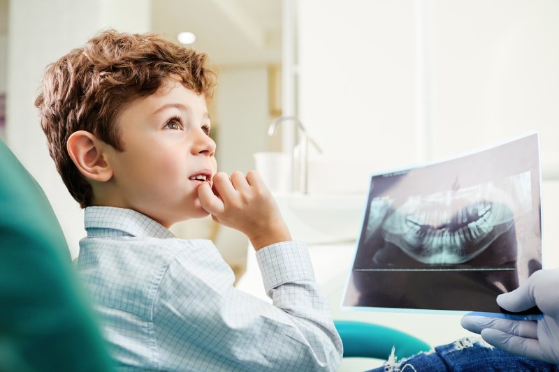 Child patient looking at X-ray of teeth