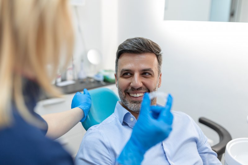 a man smiling while talking to the dentist
